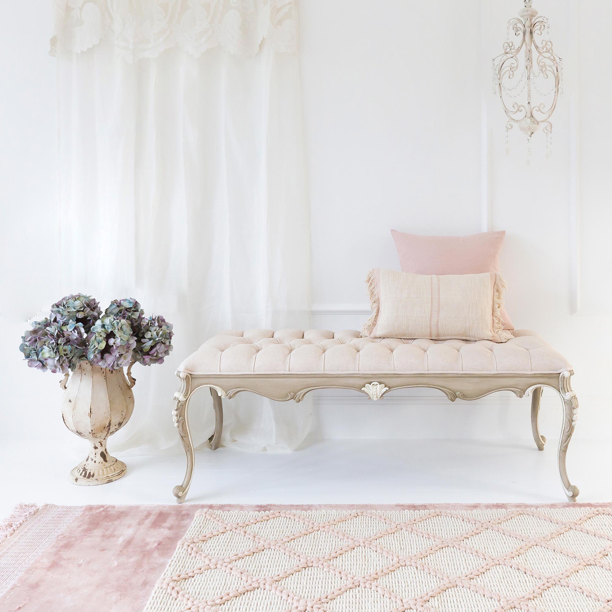 light wood bench with decorative braiding and cream buttoned cushion 