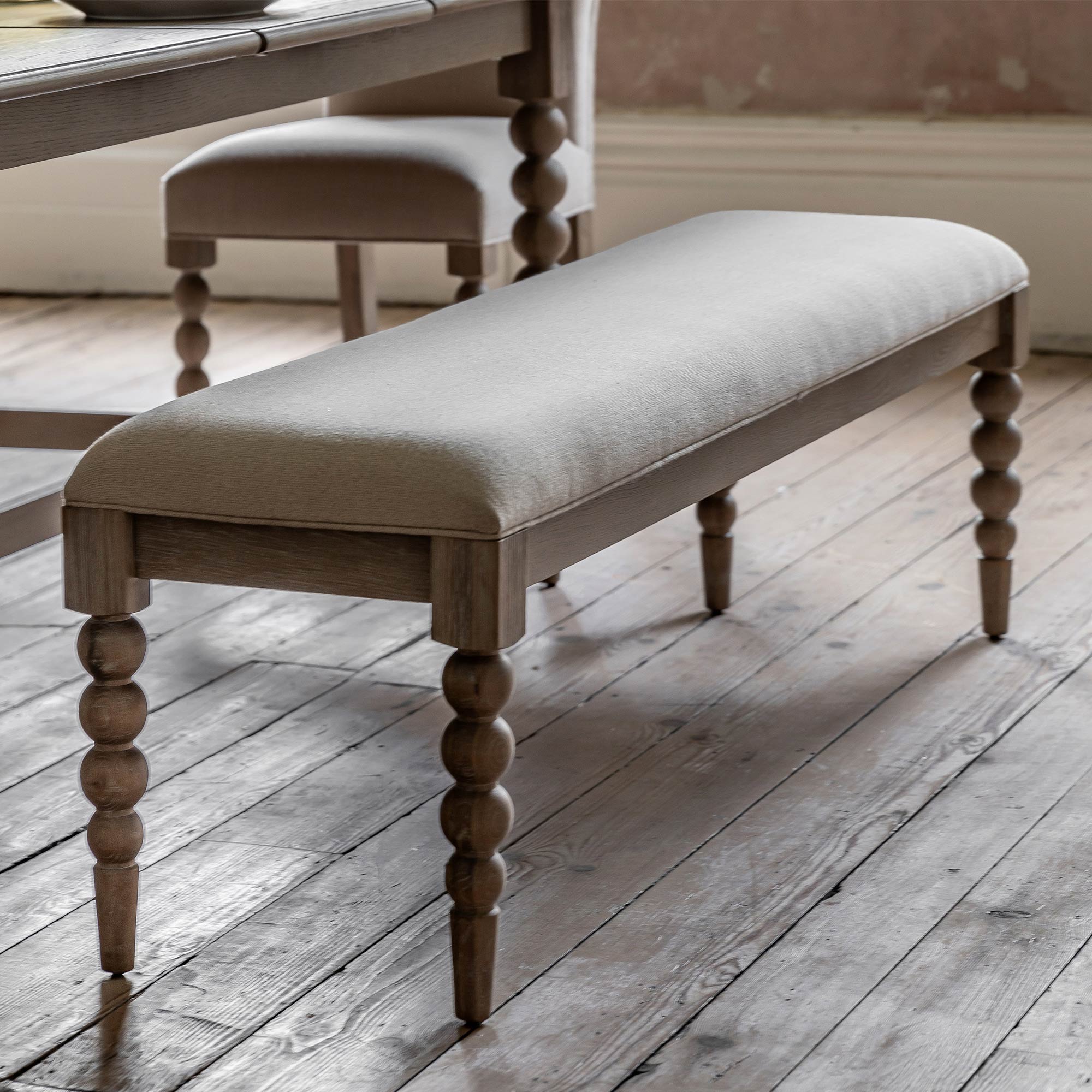 light oak bench with ivory cushion and circular details on legs 