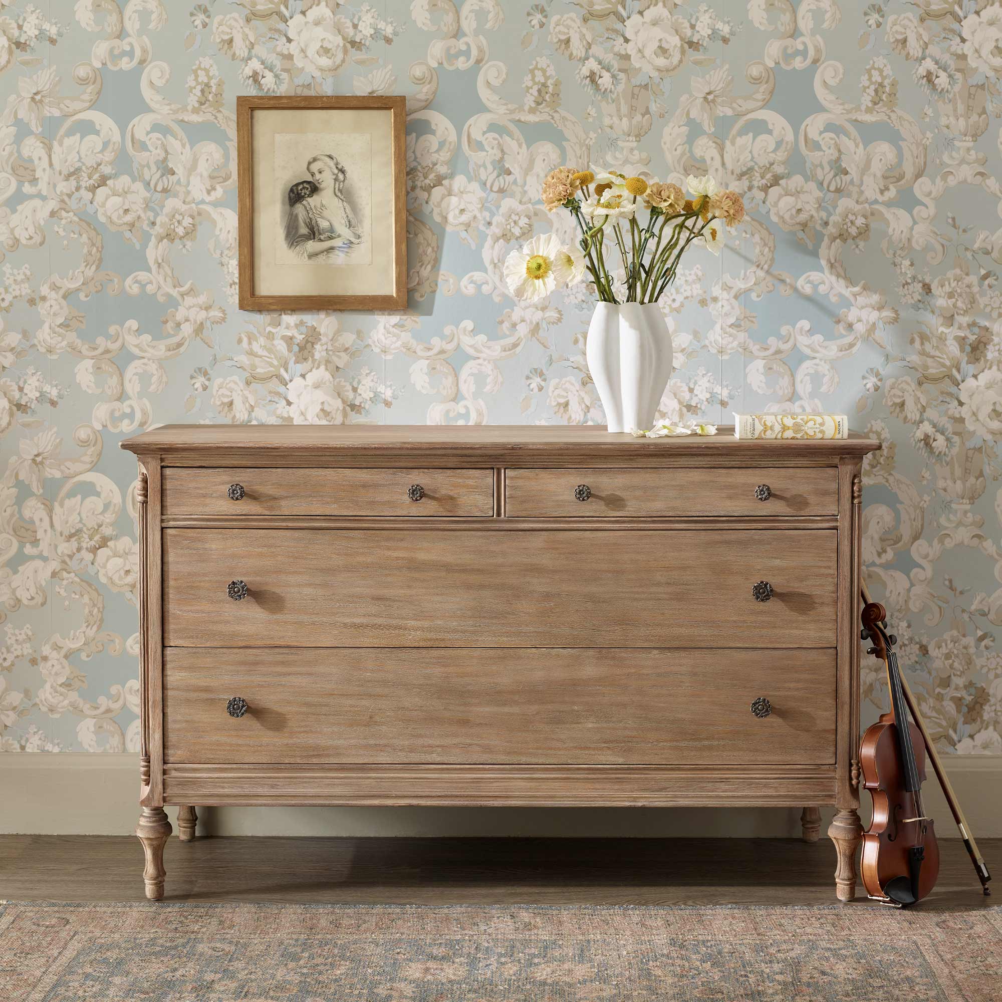 wooden chest of drawers with fluted legs and floral brass handles  